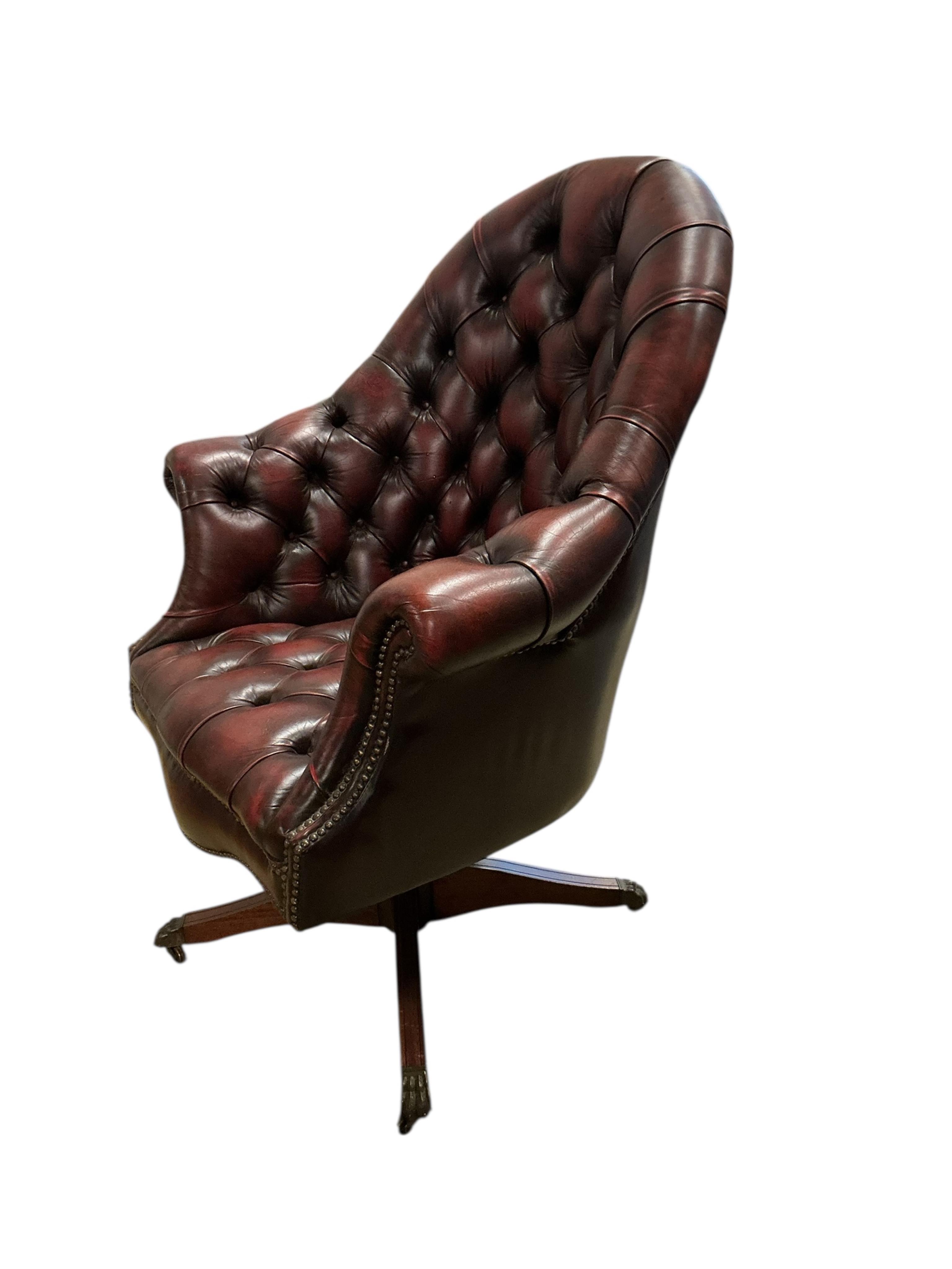 A reproduction buttoned burgundy leather swivel desk chair, width 80cm, depth 70cm, height 110cm
